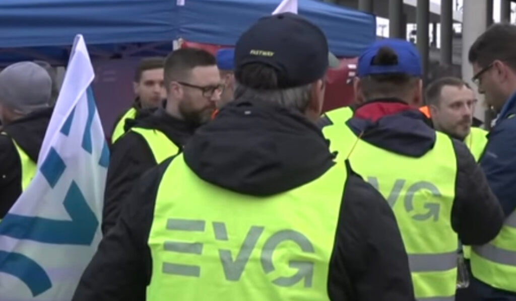 Eine Gruppe von Personen, die Warnwesten mit dem Aufdruck „EVG“ auf der Rückseite trugen, versammelte sich bei einer Veranstaltung im Freien